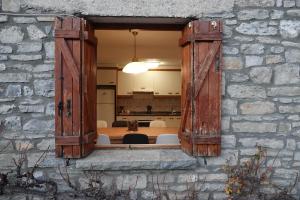 an open window in a stone wall with a table at Cirjuana, casa en el centro con agradable jardín y barbacoa in Biescas