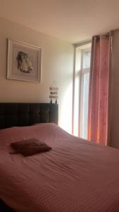 1 dormitorio con 1 cama con manta roja y ventana en Loft de Ciney, en Ciney
