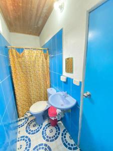 een blauwe badkamer met een toilet en een wastafel bij HOSTAL EL DESCANSO in Capurganá