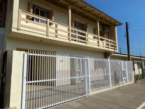 valla blanca frente a una casa con balcón en Apto 103 Maria Helena, en Torres