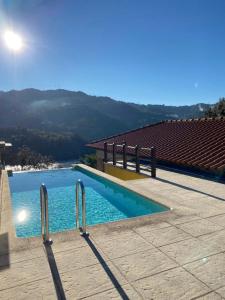 a swimming pool with a view of a mountain at Gerês Country Stays - Lagar in Rio Caldo