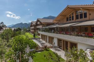 a large building with a lawn in front of it at Hotel Spitzhorn Superieur in Gstaad