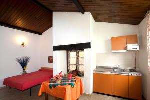- une cuisine avec un évier et une table dans une chambre dans l'établissement Residence San Damiano - Location Appartements, Studios & Chambres, à Algajola