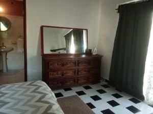 een slaapkamer met een dressoir en een spiegel bij Caribbean Paradise in Cancun