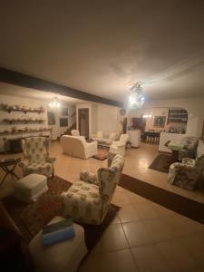 a large living room with white chairs and tables at B&B la Casa del Sole in Manzano