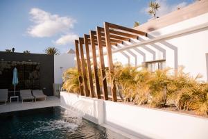 a house with a swimming pool next to a building at Aevum Resort in Playa del Ingles +17 photos