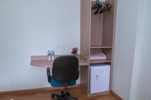 a desk with a chair next to a book shelf at Hotel Bandeirantes in Cachoeira do Campo