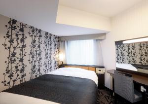 ein Hotelzimmer mit einem Bett und einem Fenster in der Unterkunft APA Hotel & Resort Niigata Ekimae Odori in Niigata