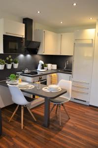 uma cozinha com uma mesa e cadeiras e um frigorífico em Gemütliches und Modernes Apartement in Grünen Top-Lage Münster em Münster