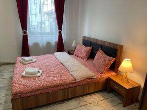 sypialnia z łóżkiem z czerwoną pościelą i poduszkami w obiekcie Tampa Residence w Braszowie