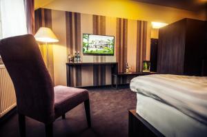 Hotel Figa في Plewiska: غرفه فندقيه سرير وتلفزيون