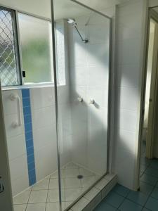 a shower with a glass door in a bathroom at Bayview Harbourview Apartments in Mooloolaba