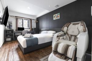 スウォンにあるSuwon Dono1796 Hotelのベッド、デスク、椅子が備わるホテルルームです。