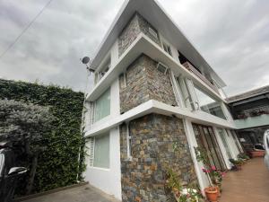 una casa con una pared de ladrillo y ventanas en Hotel Shalom, en Riobamba