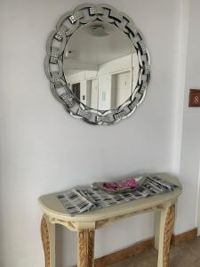 una mesa con un espejo en la pared en Hotel Shalom en Riobamba