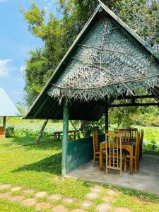 a table and chairs under a large umbrella at Meegahapokuna Resort in Anuradhapura