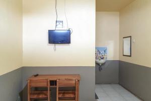 a room with a tv on the wall at Tengger Indah Bromo Homestay at Desa Wisata Bromo Mitra RedDoorz in Probolinggo