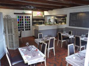 a restaurant with tables and chairs and a bar at Le Chapeau Rouge in Lusignan