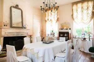 - une salle à manger avec une table, des chaises et un miroir dans l'établissement Château Beauséjour, à Listrac-Médoc