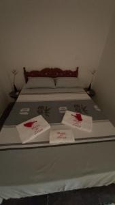 a bed with two white towels on top of it at Guest House Boki da Zezé in Marau