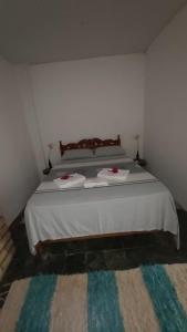 a bedroom with a bed with two towels on it at Guest House Boki da Zezé in Marau