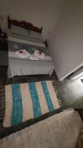 a bedroom with a bed with a rug on the floor at Guest House Boki da Zezé in Marau
