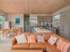 un soggiorno con divano e cucina di Castaway Bach - Whangamata Holiday Home a Whangamata