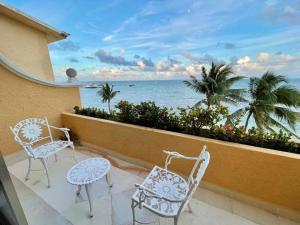Un balcón con sillas y vistas al océano. en All Ritmo by Andiani Travel en Cancún