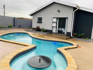 a swimming pool in front of a house at K4 Bed and Breakfast in Maseru