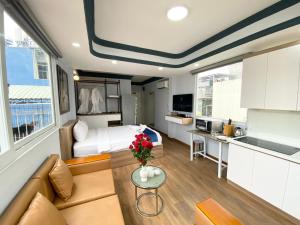 Cette petite chambre comprend un lit, un canapé et une cuisine. dans l'établissement Home Away Homestay, City Center, D1, à Hô-Chi-Minh-Ville