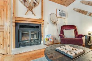 a living room with a fireplace and a table at Cabin on the Loop-Upper in Three Lakes