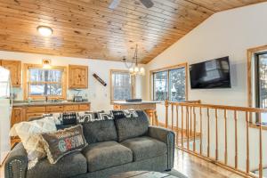 een woonkamer met een bank en een tv bij Cabin on the Loop-Upper in Three Lakes