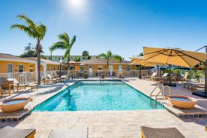 einen Pool mit Stühlen und Sonnenschirmen in einem Resort in der Unterkunft Upham Beach Inn in St Pete Beach