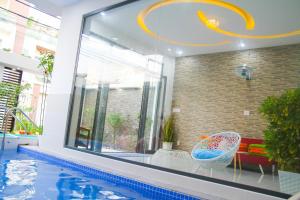 Cette chambre dispose d'une piscine avec une grande fenêtre. dans l'établissement Hoàng My Villa, à Vung Tau