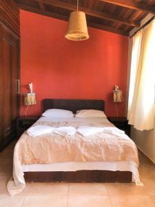 a bedroom with a large bed with a red wall at Triplex vista mar no Pipa Beleza in Pipa