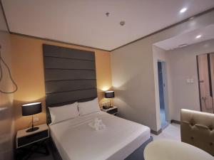 a bedroom with a large white bed and a chair at Yes Hotel Pandi Bulacan in Pandi