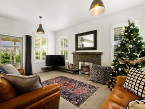 a living room with a christmas tree and a television at Fletcher Cottage in Arrowtown