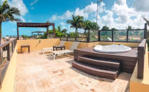 um pátio com uma banheira de hidromassagem no topo de um edifício em Triplex vista mar no Pipa Beleza em Pipa