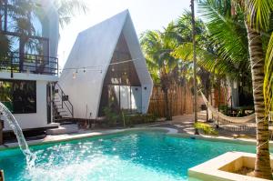 a house with a swimming pool in front of a house at Xtambaa Cabins & Spa Only Adults in El Cuyo