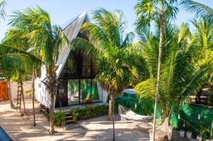 een huis met palmbomen ervoor bij Xtambaa Cabins & Spa Only Adults in El Cuyo