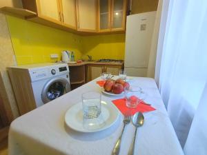 uma cozinha com uma mesa com dois pratos e copos em 1 комнатные апартаменты на Ауэльбекова 138 em Kokshetau