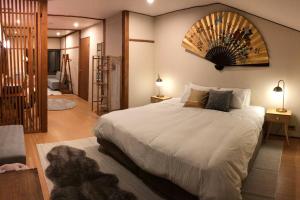 a bedroom with a large white bed with a large mirror at Ski In Ski Out Myoko. Luxury Chalet sleeps 12 in Akakura