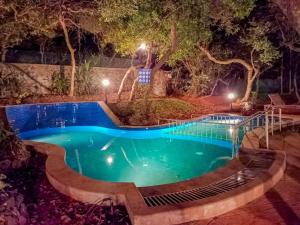 a swimming pool at night with lights at Advait Resort Kshetra Mahabaleshwar in Mahabaleshwar