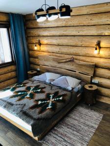 a bedroom with a large bed with a wooden wall at fazenda slavsko in Slavske