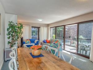 Una sala de estar con una mesa y sillas de madera. en Bay Parklands, 62 2 Gowrie Avenue - Wifi, Pool, Tennis, Water Views & Aircon, en Nelson Bay