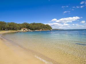 Una vista de una playa con árboles y el agua. en Bay Parklands, 62 2 Gowrie Avenue - Wifi, Pool, Tennis, Water Views & Aircon, en Nelson Bay