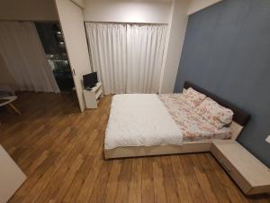 a small bedroom with a bed and a television at P C Homes at Belliza near airport in Surat