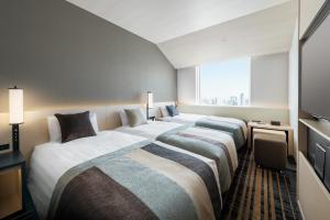 Postel nebo postele na pokoji v ubytování Hotel Hankyu RESPIRE OSAKA
