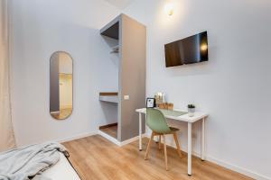 een kamer met een bureau en een tv aan de muur bij ORAZIO INN SUITE in Rome