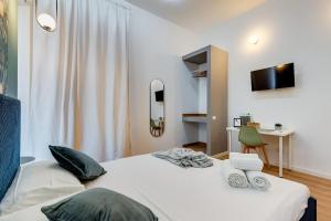 een slaapkamer met een wit bed met een stoel en een bureau bij ORAZIO INN SUITE in Rome